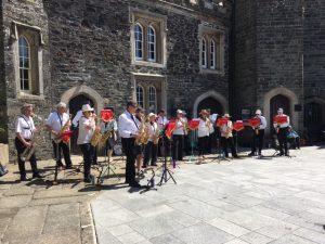 Saxaphonics playing outside in the blazing sunshine wearing an interesting selection of sun hats and sunglasses