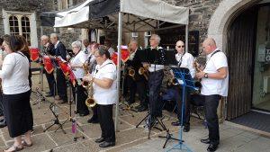 Saxophonics playing outside - with a small gazebo to shelter some of the band.